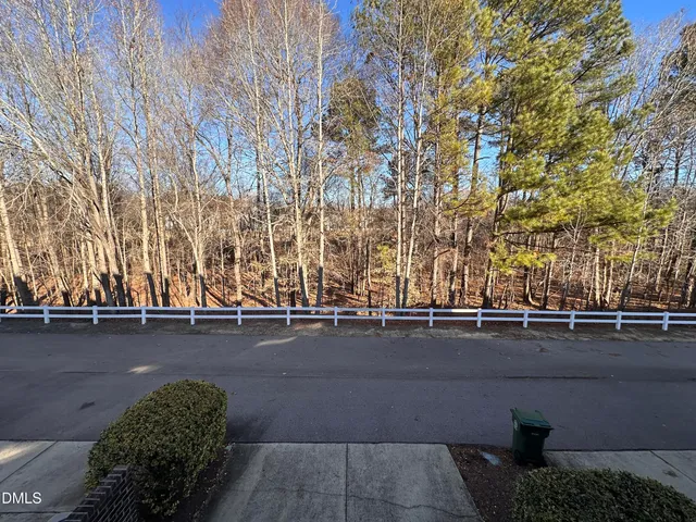 a view of a city street with a building and trees in the background