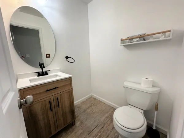 a bathroom with a toilet a sink and mirror