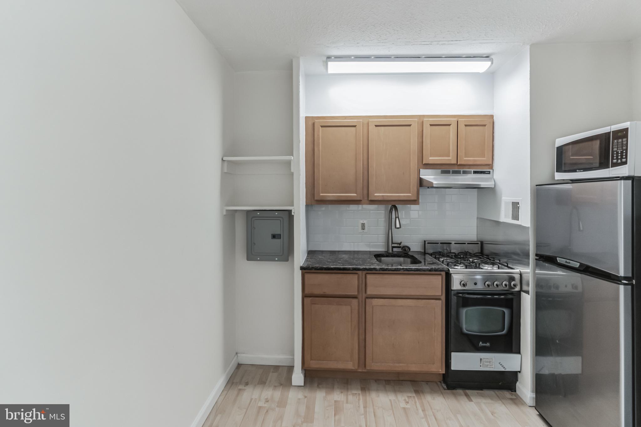 2101 Chestnut Street, Unit 1102 Philadelphia, PA 19103 - Photo 9 of 17 a kitchen with a sink stove and microwave