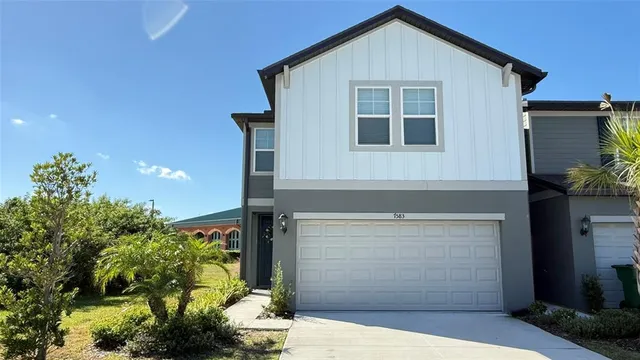 a front view of a house with a yard and garage