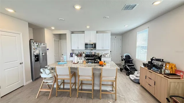 a kitchen with a refrigerator and a stove top oven