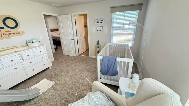a living room with furniture and a baby crib