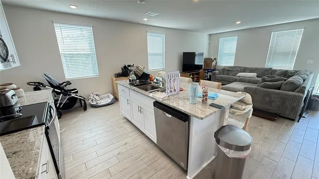 a living room with furniture a flat screen tv and a large window