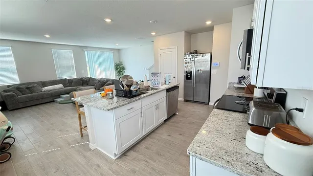 a kitchen with stainless steel appliances granite countertop a sink a stove and a refrigerator
