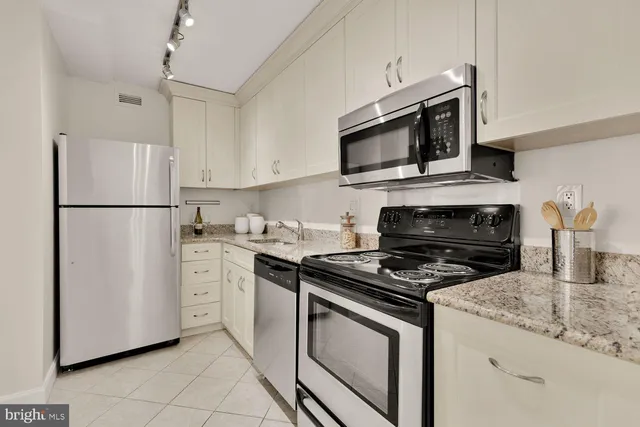 a kitchen with cabinets stainless steel appliances and a counter space
