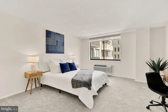 a bedroom with a bed lamp and a potted plant