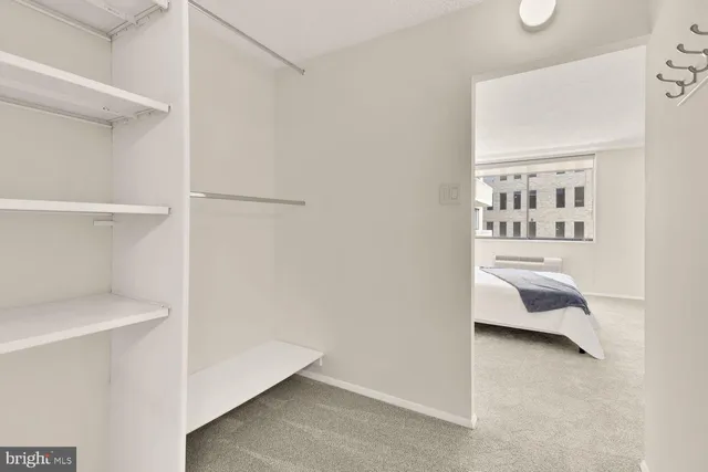 a bedroom with a bed and a view of living room