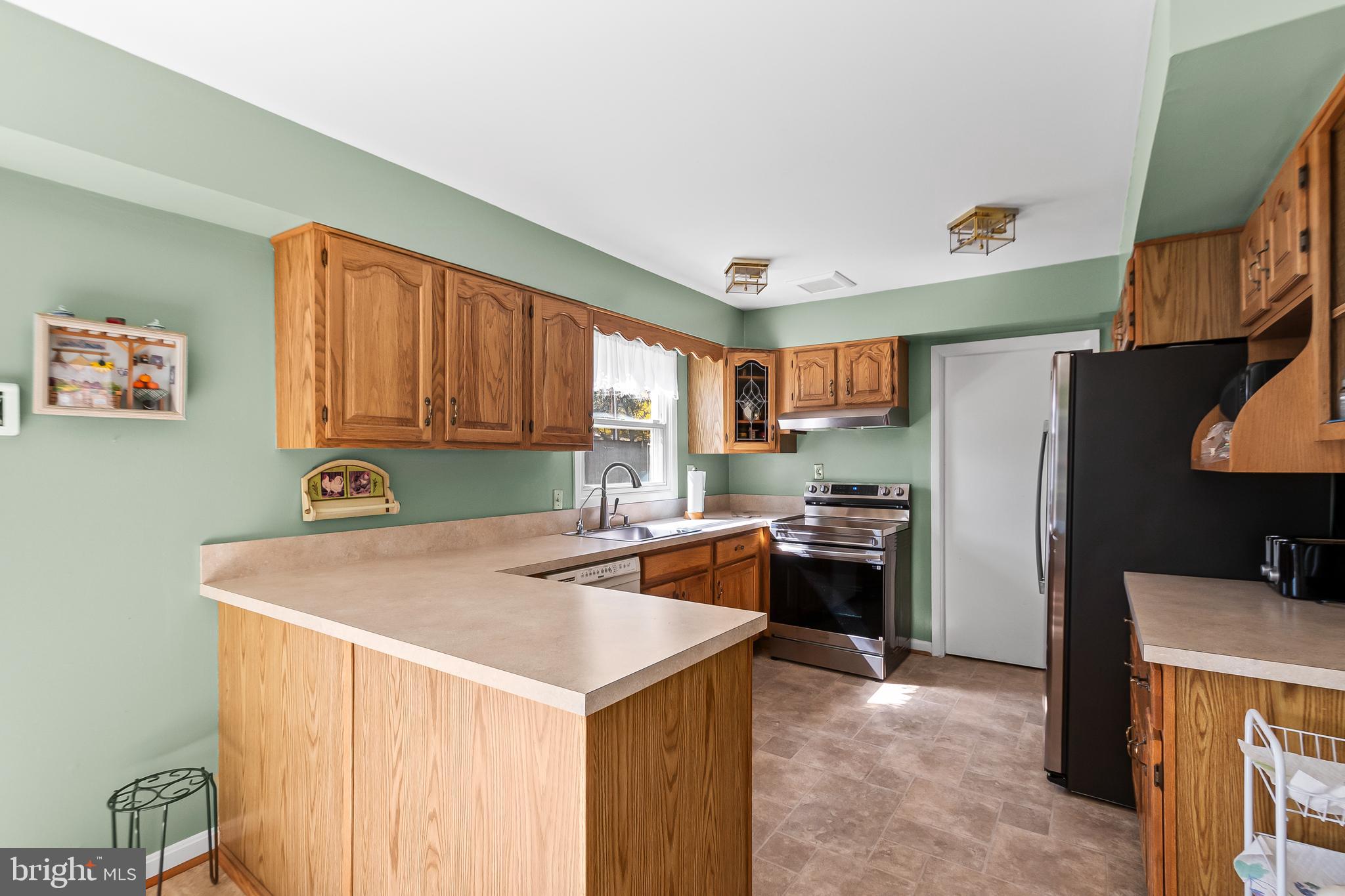 12613 Knowledge Lane Bowie, MD 20715 - Photo 13 of 32 a kitchen with stainless steel appliances granite countertop a sink stove and refrigerator