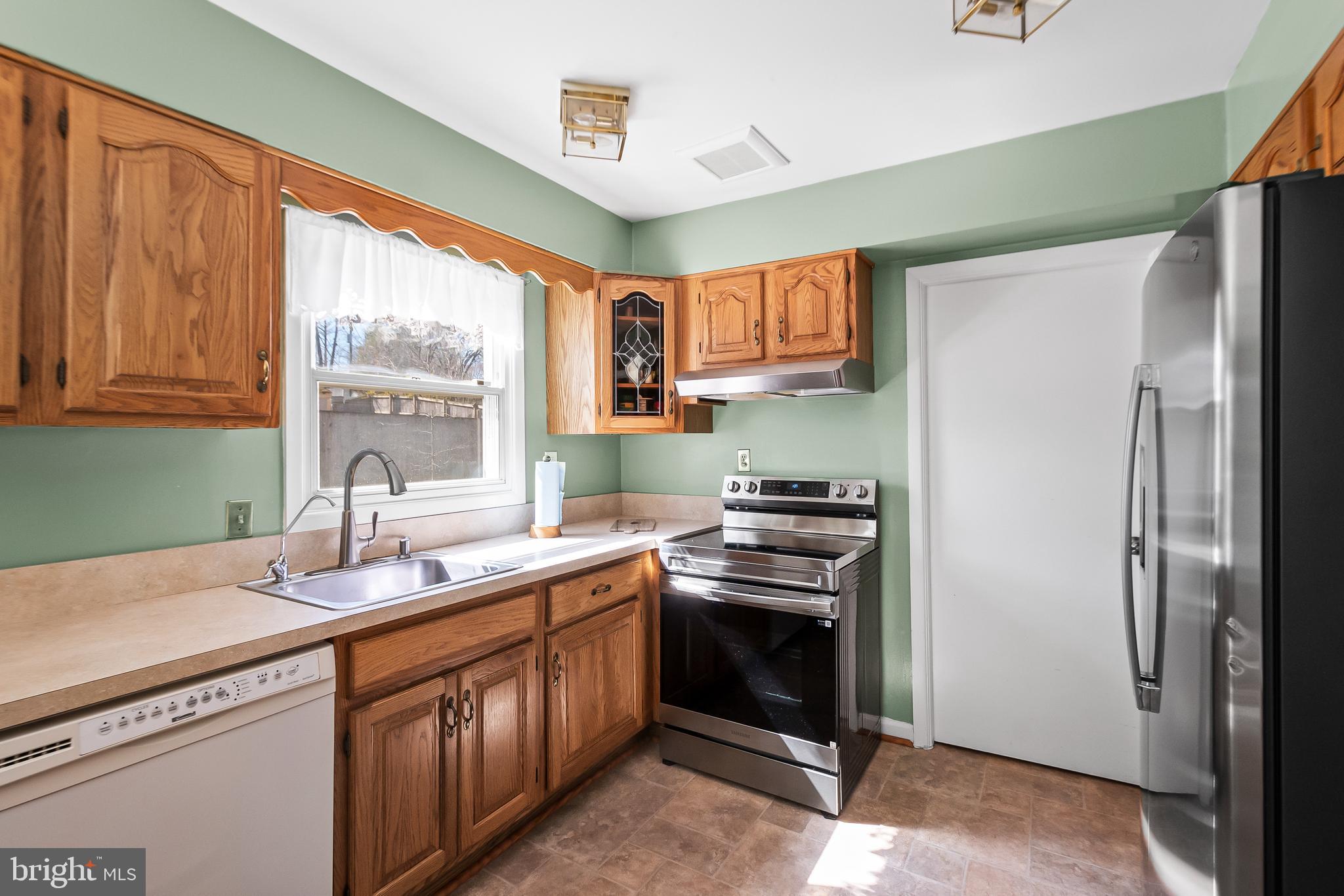 12613 Knowledge Lane Bowie, MD 20715 - Photo 14 of 32 a kitchen with stainless steel appliances a sink cabinets and a window