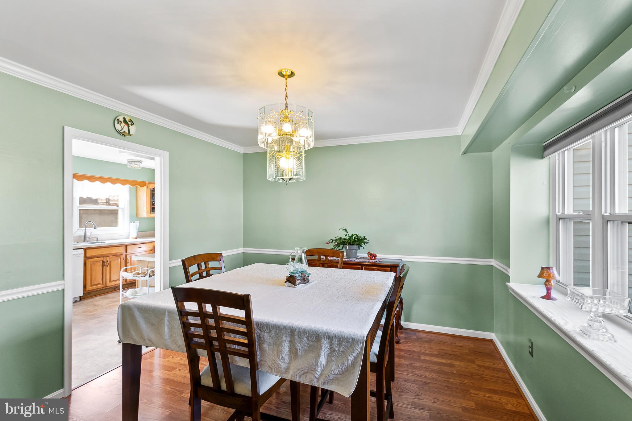 12613 Knowledge Lane Bowie, MD 20715 - Photo 9 of 32 a view of a dining room with furniture a chandelier and wooden floor