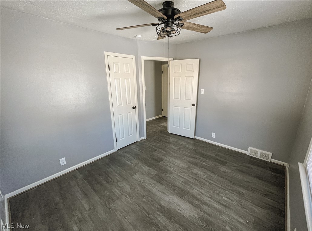 24709 Emery Road Warrensville Heights, OH 44128 - Photo 15 of 34 Empty room with dark hardwood / wood-style flooring and ceiling fan
