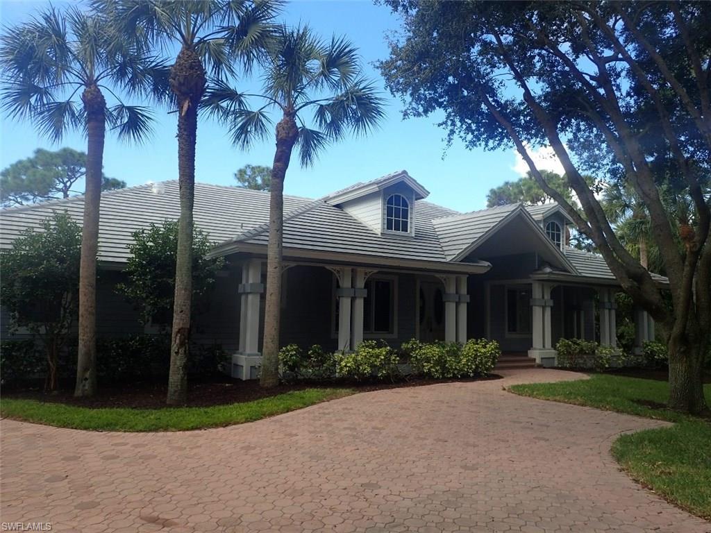 11623 Useppa Court Naples, FL 34110 - Photo 2 of 9 a front view of a house with garden