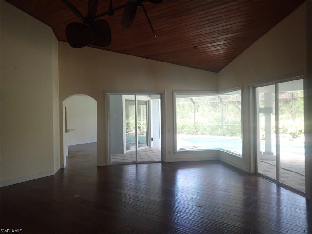 11623 Useppa Court Naples, FL 34110 - Photo 5 of 9 a view of an empty room with wooden floor and a window