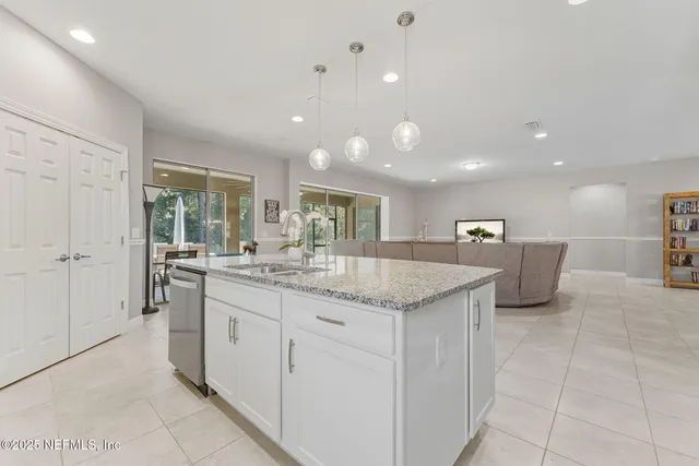 a kitchen with stainless steel appliances granite countertop a stove a sink a refrigerator and a microwave