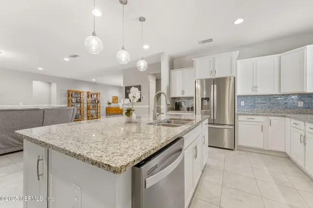 a kitchen with granite countertop a sink stainless steel appliances and cabinets