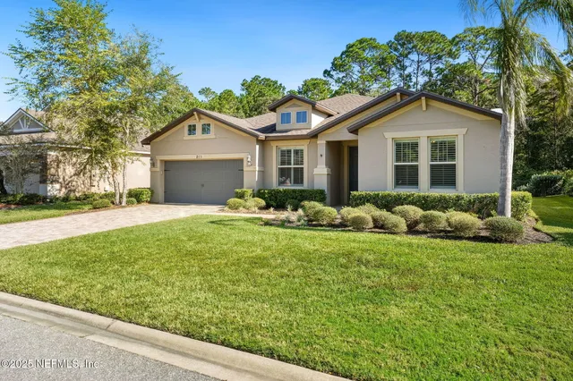a view of a house with a yard and potted plants