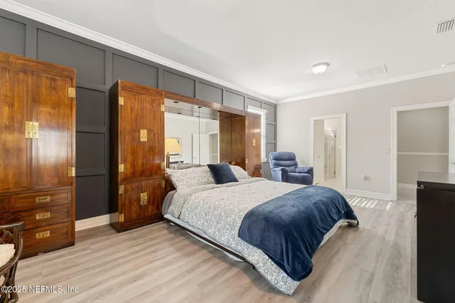 a bedroom with a bed a mirror and furniture