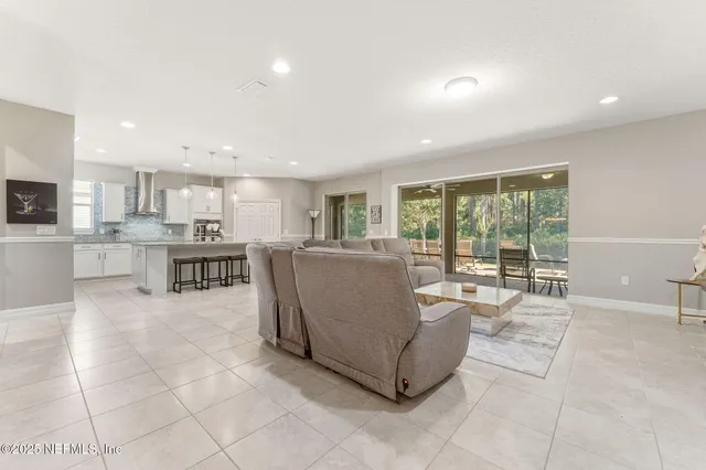 a living room with furniture and view of kitchen