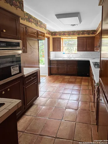 a kitchen with a stove a sink and a microwave