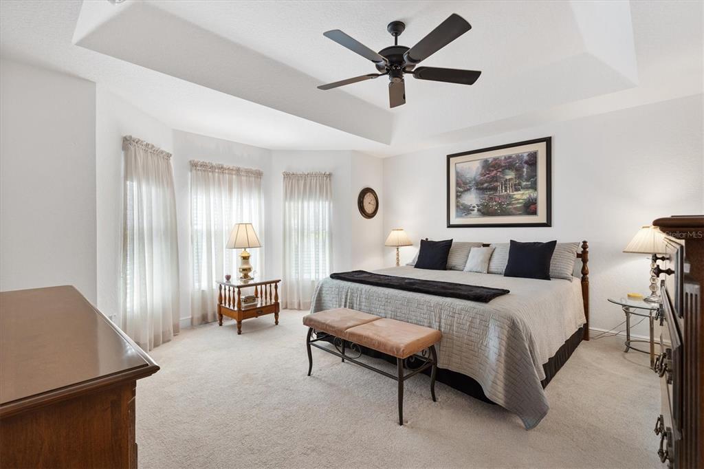 10404 Silver Maple Avenue Oxford, FL 34484 - Photo 16 of 41 a spacious bedroom with a bed a couch and a chandelier