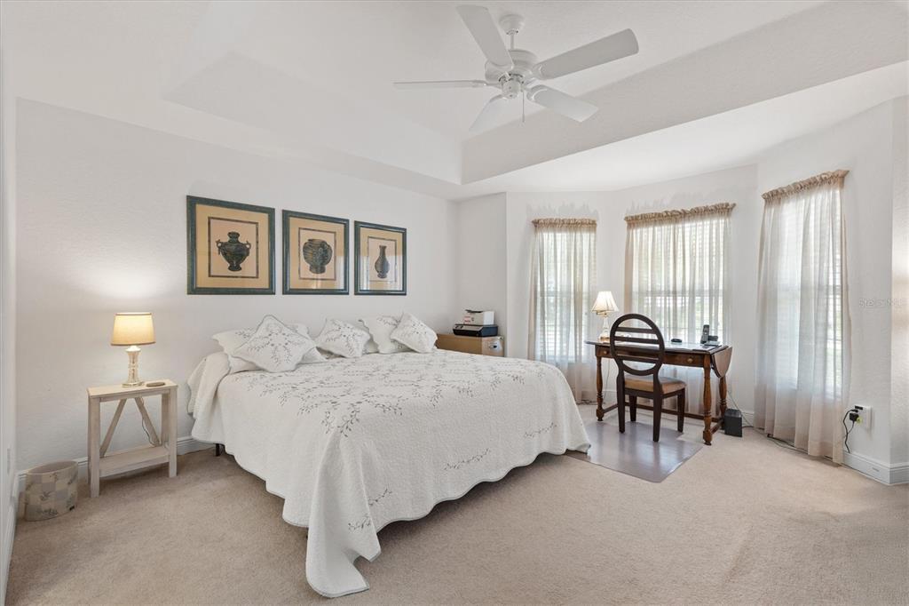 10404 Silver Maple Avenue Oxford, FL 34484 - Photo 20 of 41 a spacious bedroom with a bed and a chandelier