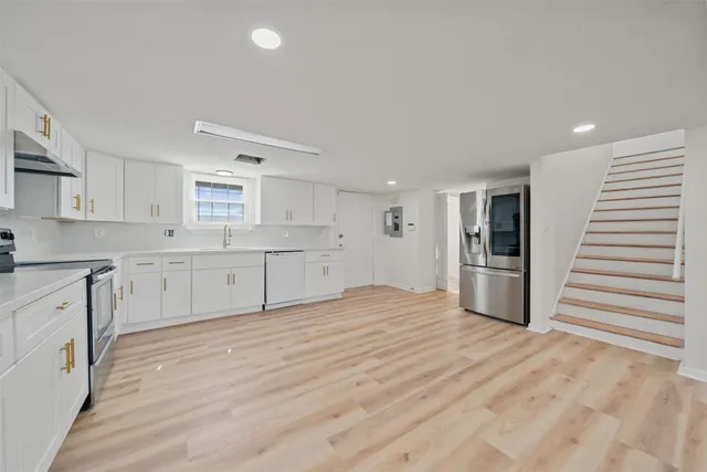 a large white kitchen with cabinets