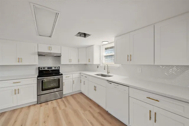 a kitchen with a stove sink and cabinets