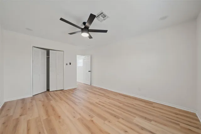a view of a big room with wooden floor and windows