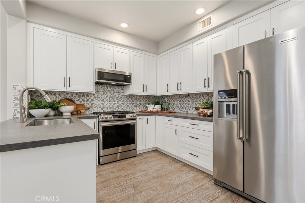 a kitchen with stainless steel appliances white cabinets and a refrigerator