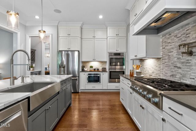 a kitchen with stainless steel appliances a sink a stove top oven a counter space and cabinets