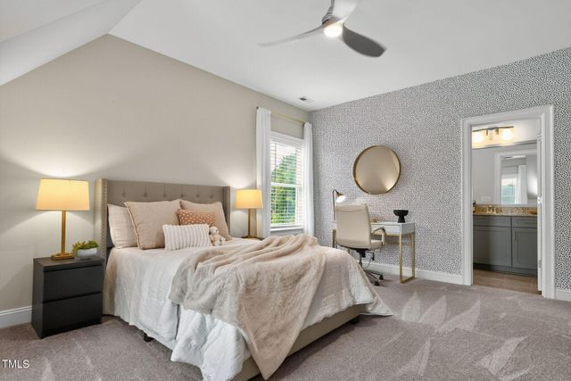 a bedroom with a bed a table and chair