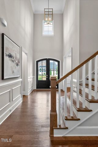 a view of a dining room with furniture a chandelier and wooden floor