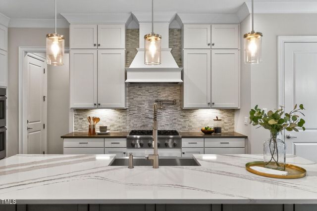 a kitchen with stainless steel appliances granite countertop a stove a sink a microwave a dining table and chairs