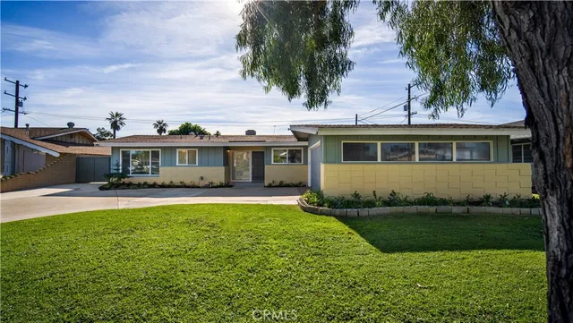 a front view of a house with a garden and yard