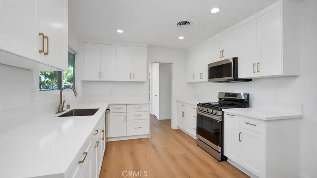 a kitchen with stainless steel appliances a stove sink microwave and cabinets