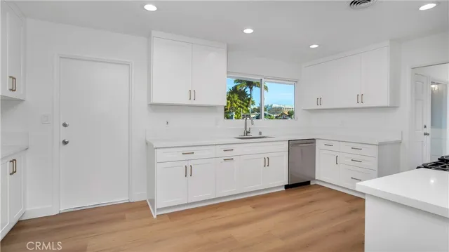a kitchen with white cabinets and white appliances