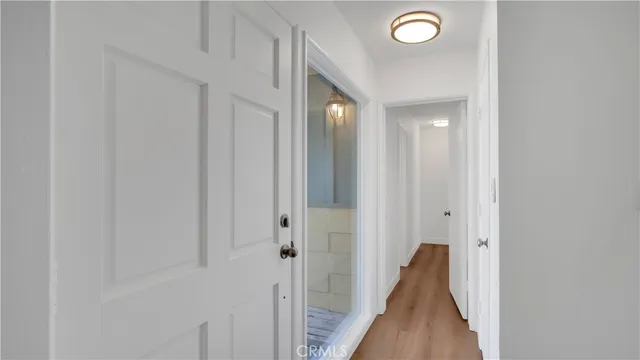 a view of a hallway with closet and wooden floor