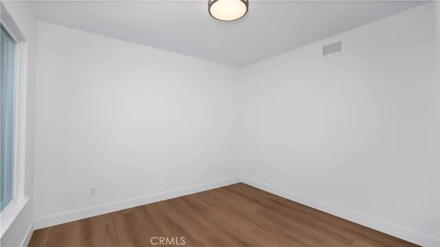 a view of a small space with wooden floor and a window