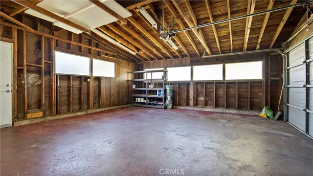 a view of an empty room with floor to ceiling window and stairs