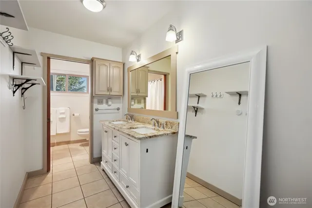 a bathroom with a granite countertop sink a mirror and a shower