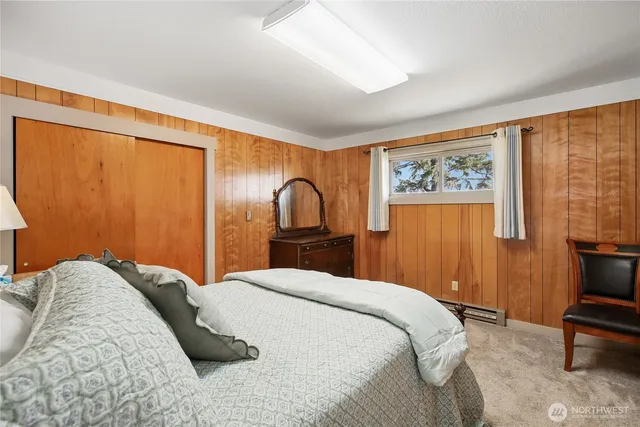 a bedroom with a bed and next to a window