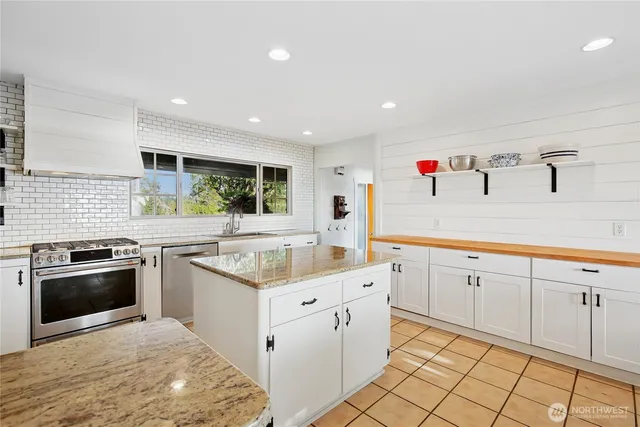 a kitchen with granite countertop white cabinets and stainless steel appliances