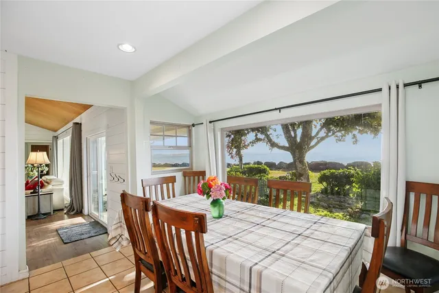 a view of a dining room with furniture large windows and wooden floor