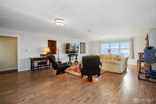 a living room with furniture and a wooden floor