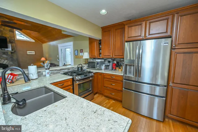 a kitchen with stainless steel appliances granite countertop a refrigerator and a sink