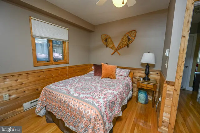 a bedroom with a bed and wooden floor