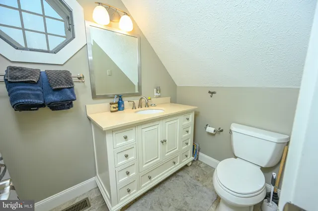 a bathroom with a toilet a sink and a mirror