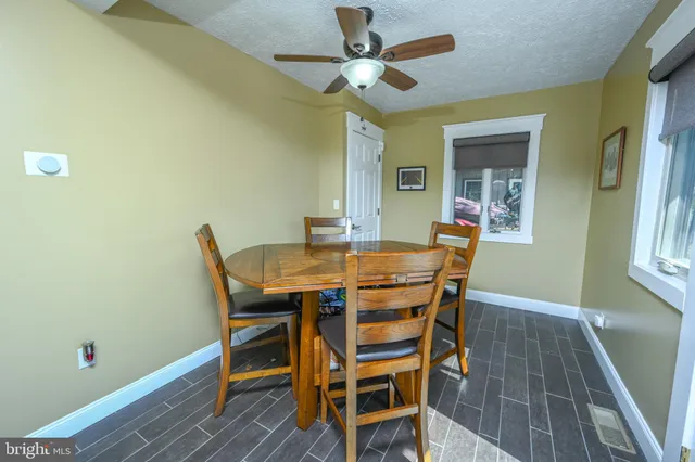 a view of a dining room with furniture and a chandelier fan