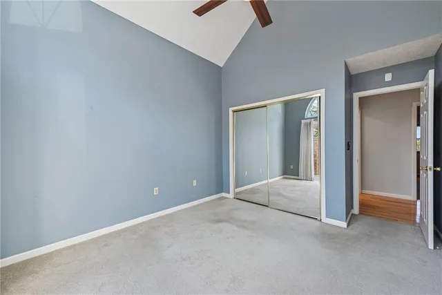 an empty room with closet and windows