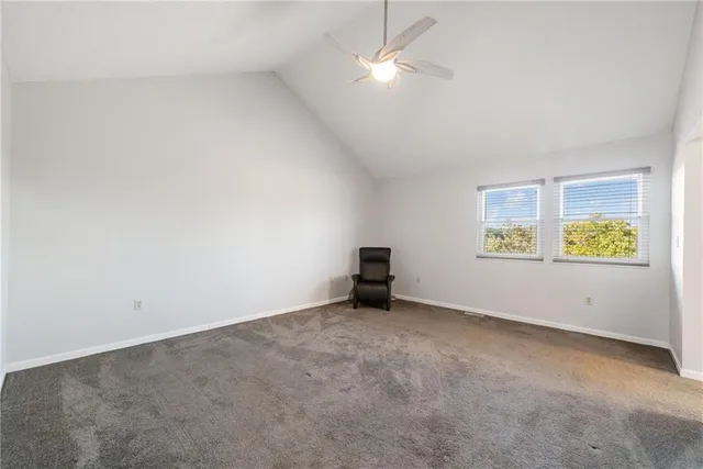 an empty room with a window and ceiling fan